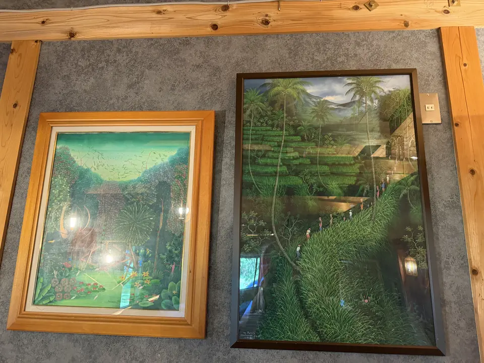 壁に並んで飾られた森の絵画2点